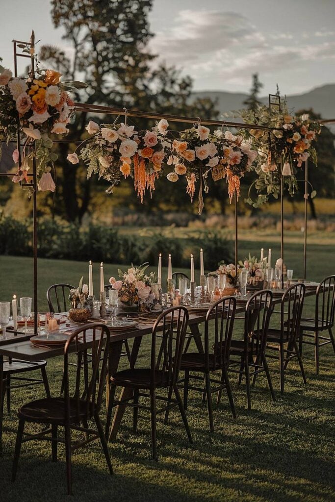 15+ idées de micro-mariages qui transformeront votre espace de cérémonie et de réception image 8 | Soirée Blanche Table de mariage extérieure intime avec fleurs suspendues et bougies.