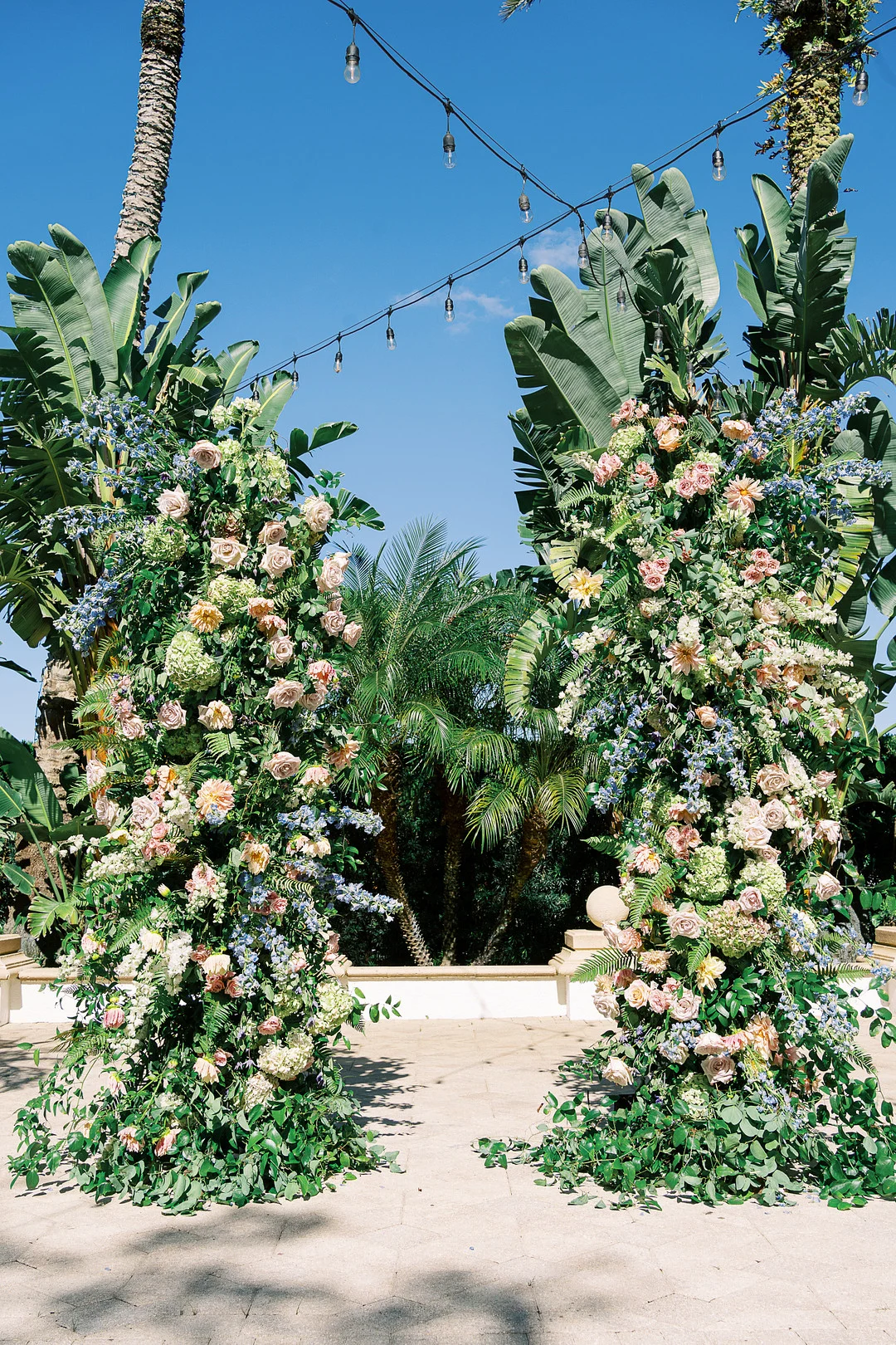 Fleurs de cérémonie tropicales avec palmiers et guirlandes lumineuses