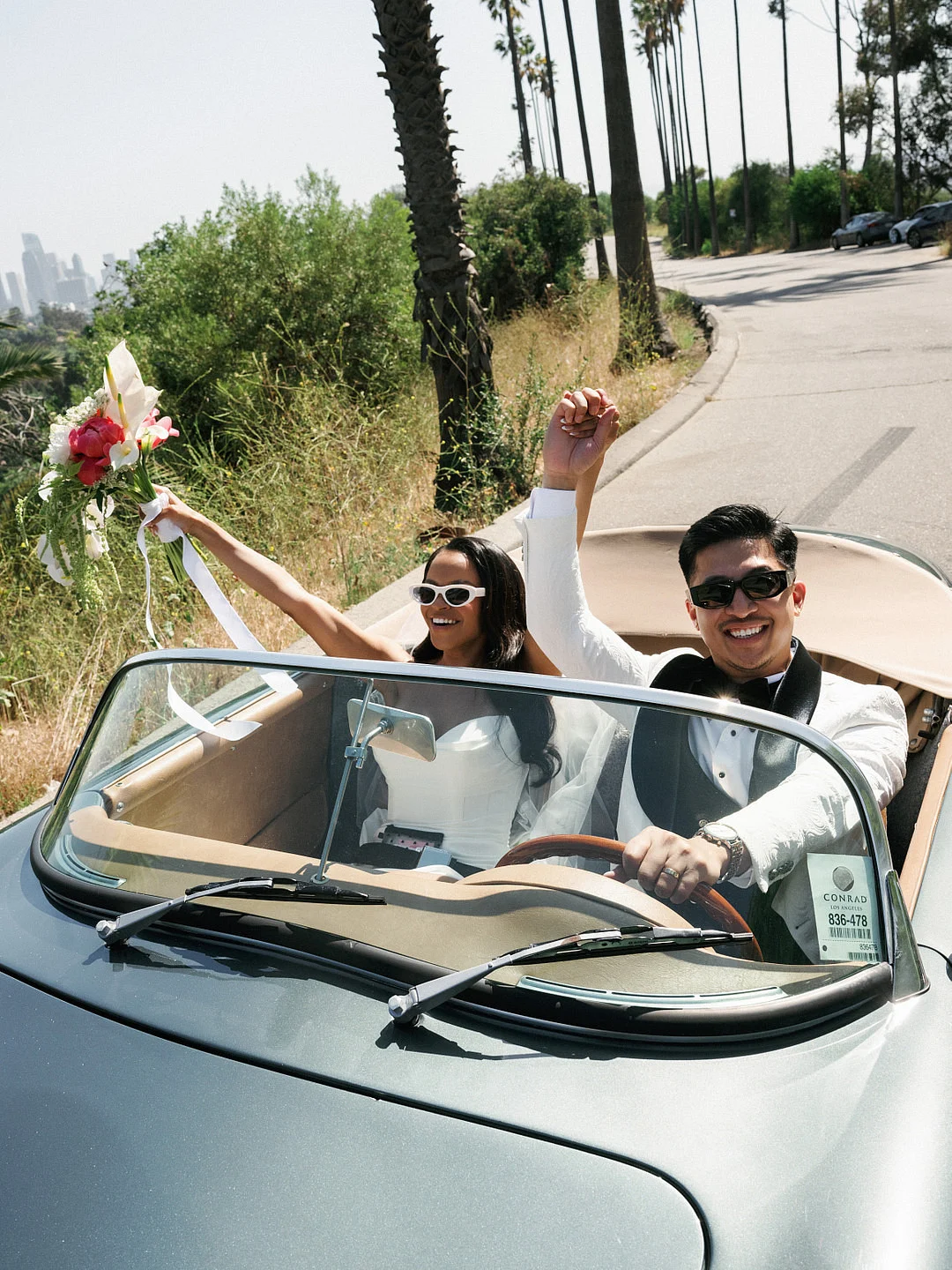 Un mariage glamour sur le toit de Los Angeles avec une Porsche vintage image 11 | Soirée Blanche La mariée dans la décapotable avec son bouquet et ses lunettes de soleil