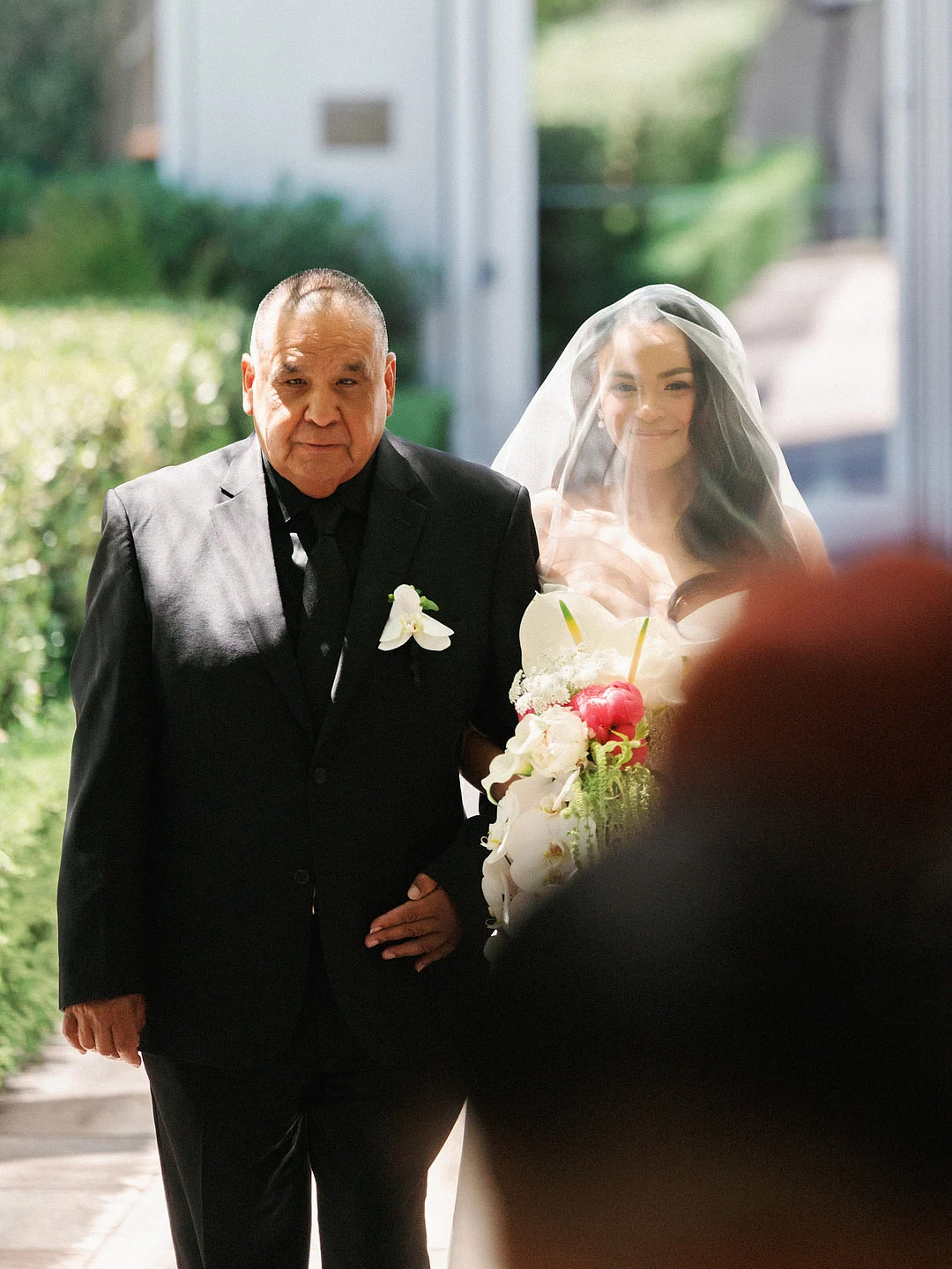 Un mariage glamour sur le toit de Los Angeles avec une Porsche vintage image 5 | Soirée Blanche Kevin embrassant le front de Dyeneka au milieu de la verdure