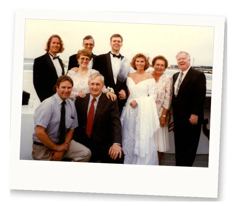 Photo de groupe de fête de mariage des années 1990 avec la mariée en robe de mariée à manches bouffantes