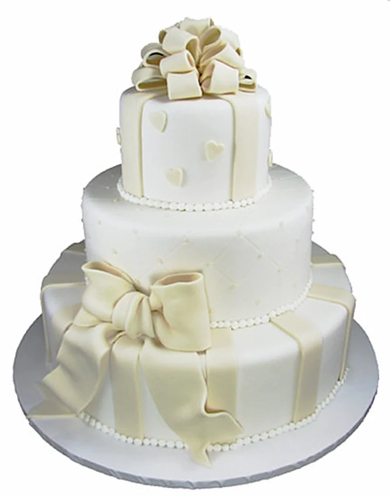 Gâteau de mariage fondant blanc décoré de cœurs, de nœuds et d'un rang de perles passepoilé