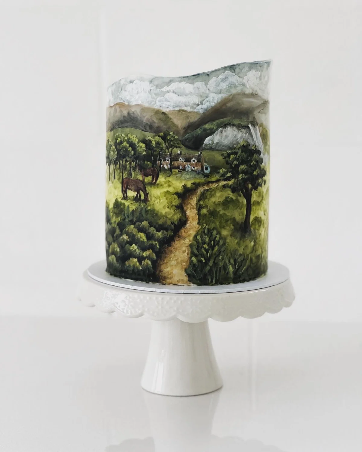 Gâteau de mariage occidental peint à la main avec une scène de campagne représentant un cheval, une ferme et un chemin sinueux