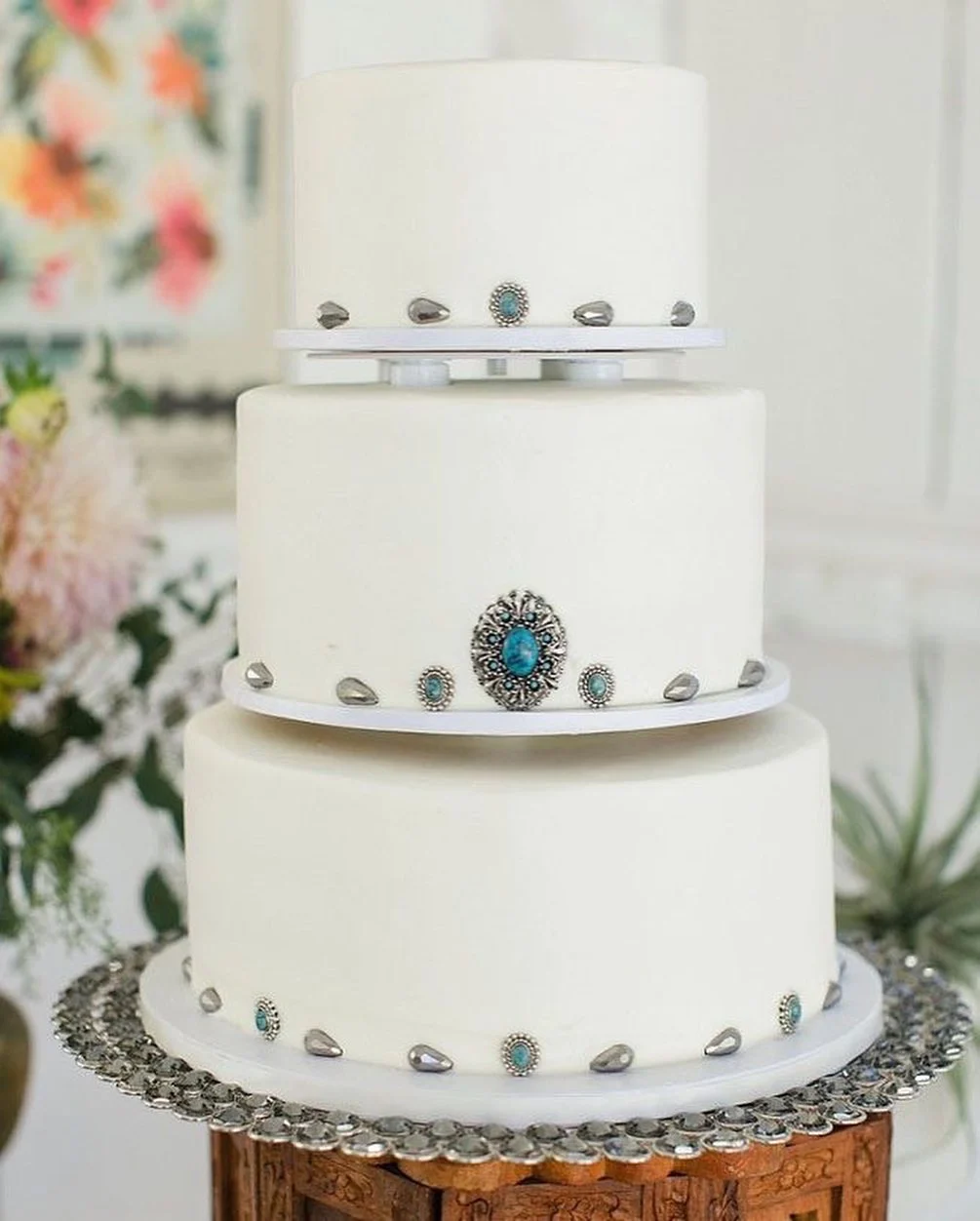 Gâteau de mariage blanc décoré de détails de concho turquoise et argent