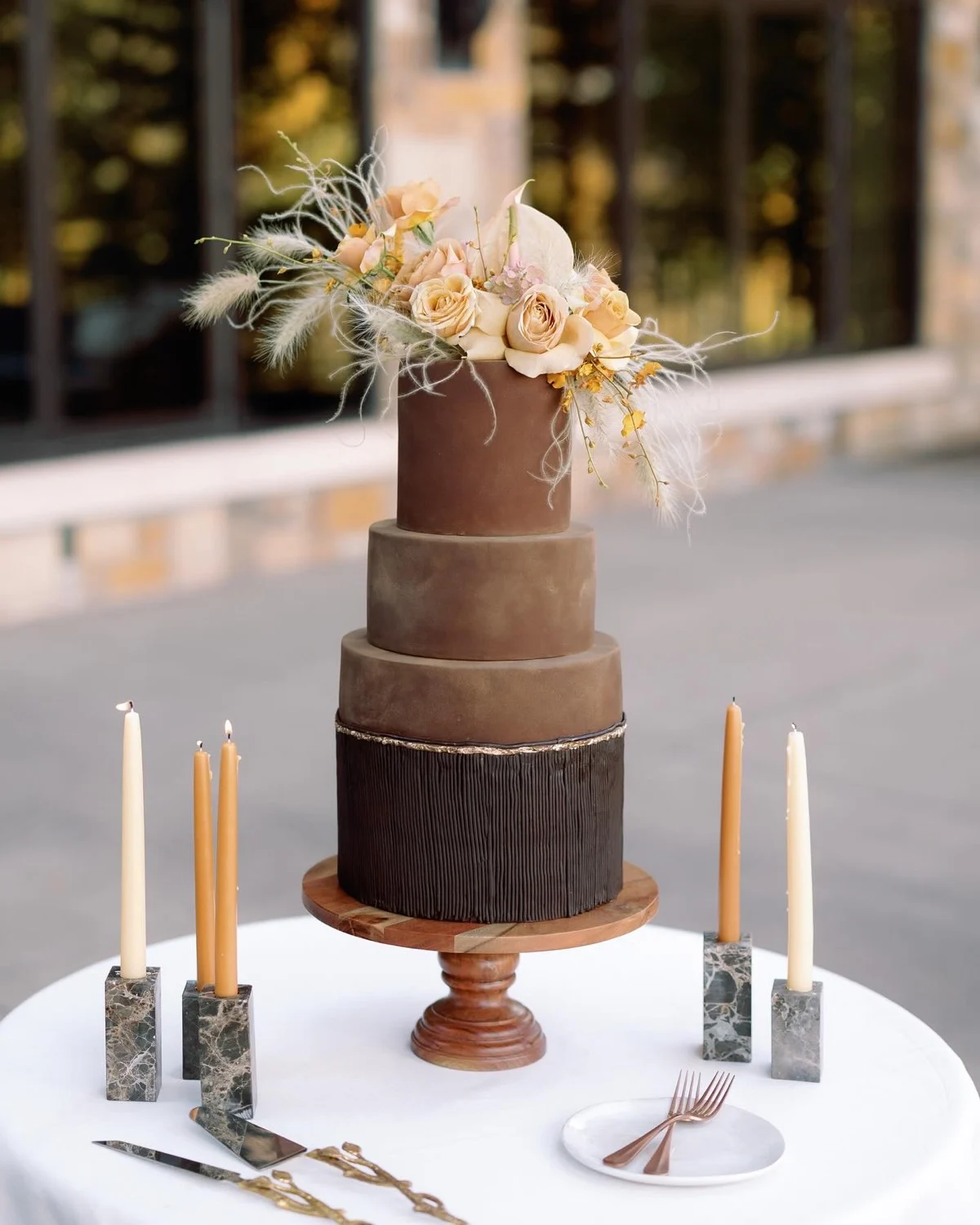 Gâteau de mariage ombré moka et chocolat avec un niveau inférieur en écorce de chocolat, des roses pêche et de l'herbe de la pampa