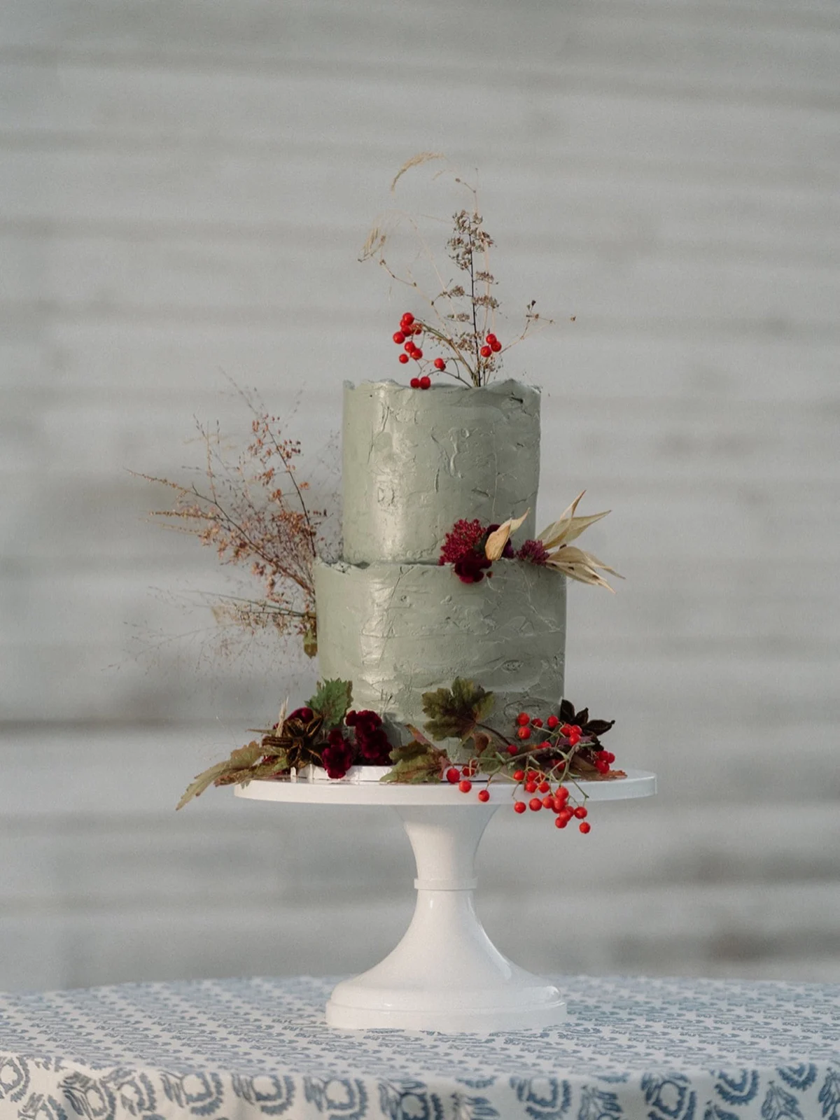 Gâteau de mariage rustique à la crème au beurre vert sauge avec fruits rouges et tiges séchées
