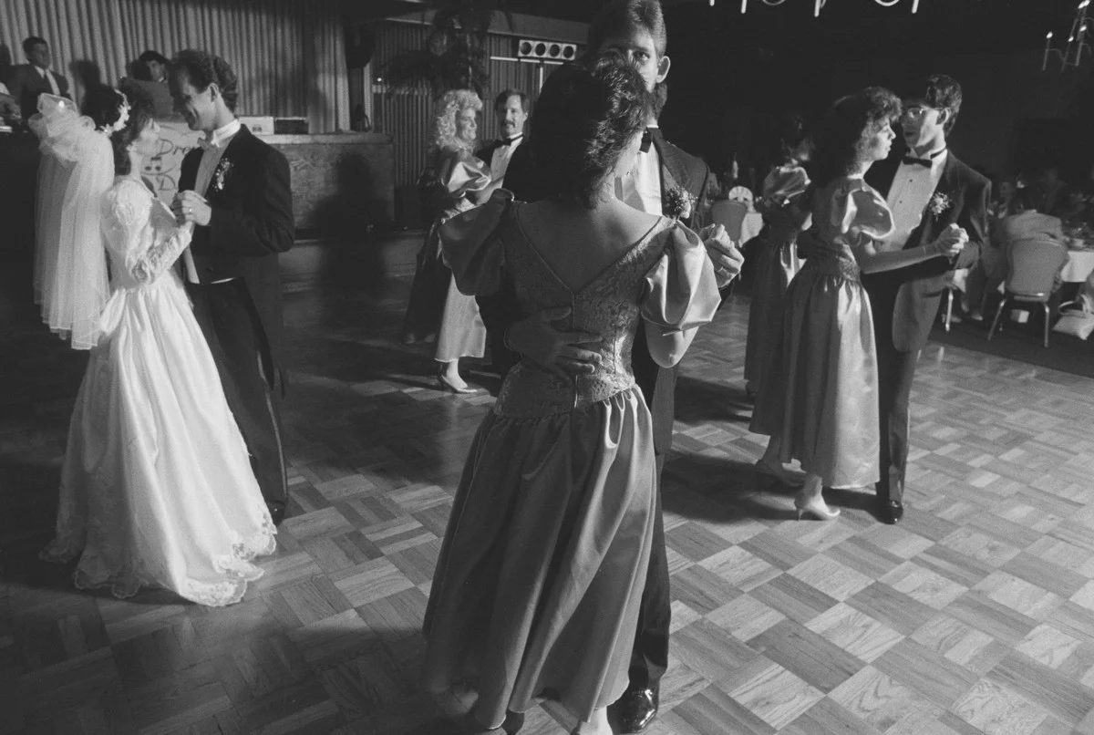 Des couples dansent lentement lors d'une réception de mariage en 1989, les mariés à gauche, les demoiselles d'honneur en robes à manches bouffantes