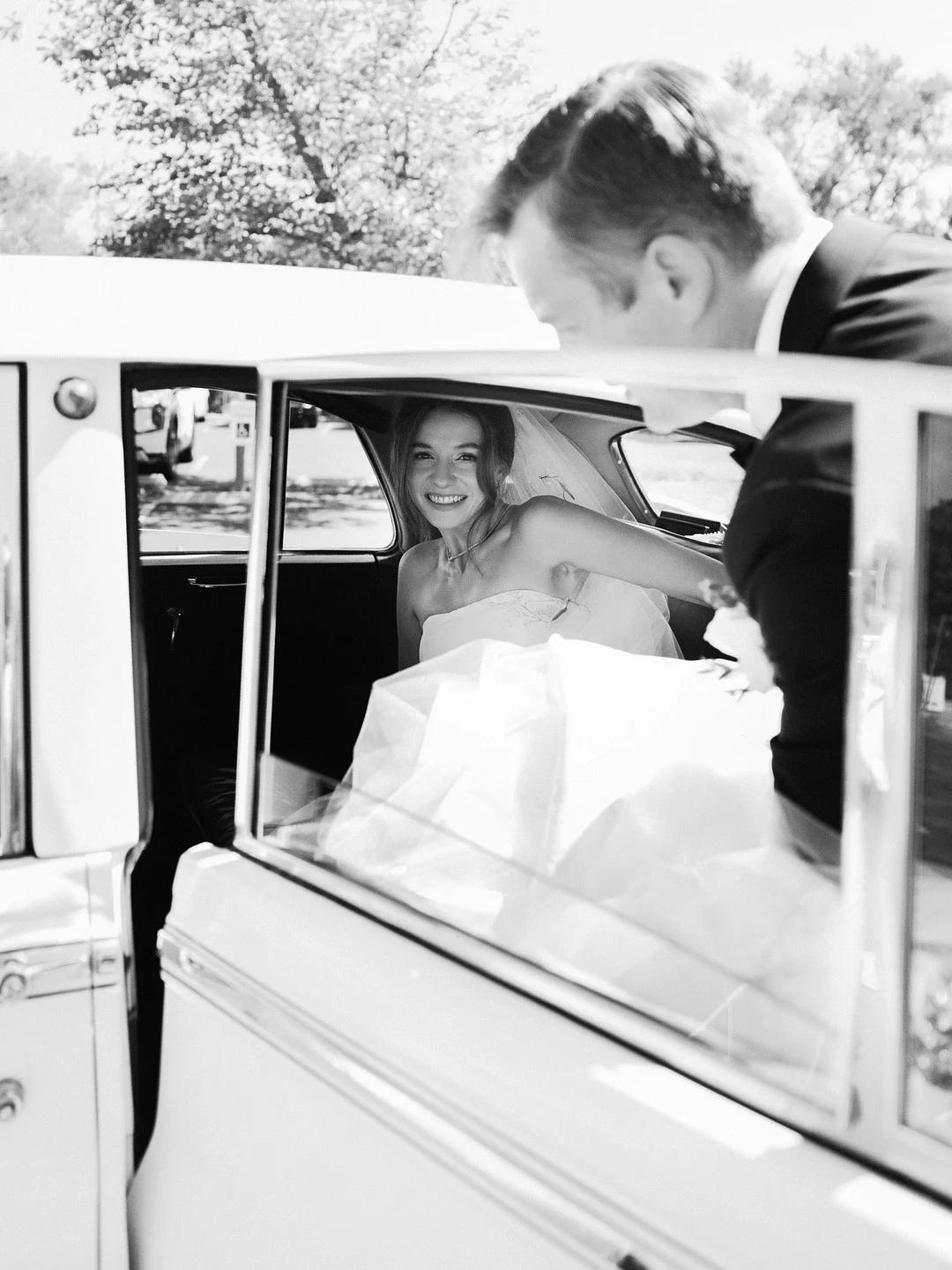 Photo en noir et blanc de Baylee arrivant à l'église dans une Bentley vintage
