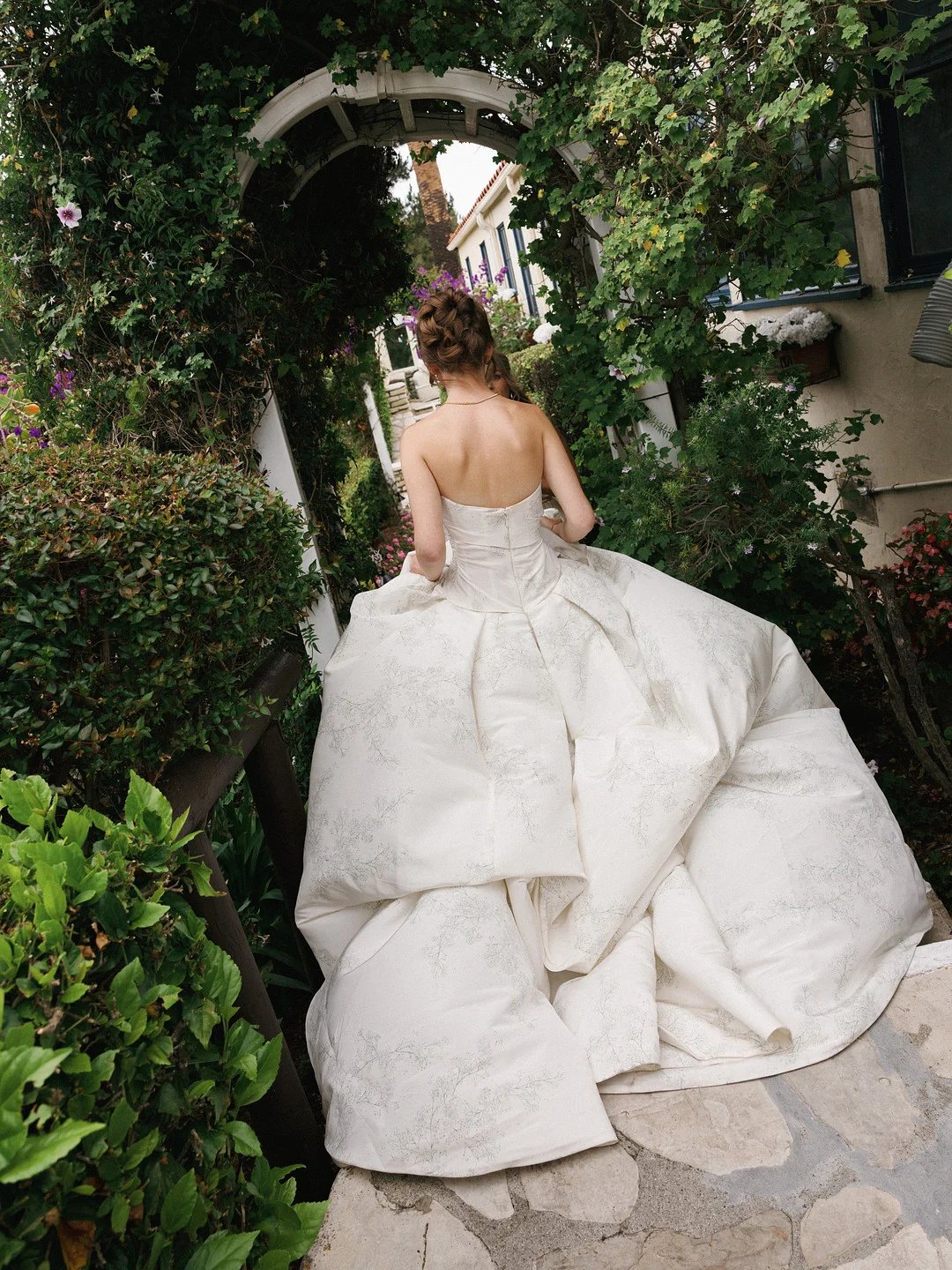 Baylee marchant sous une arche de jardin couverte de roses à La Venta Inn
