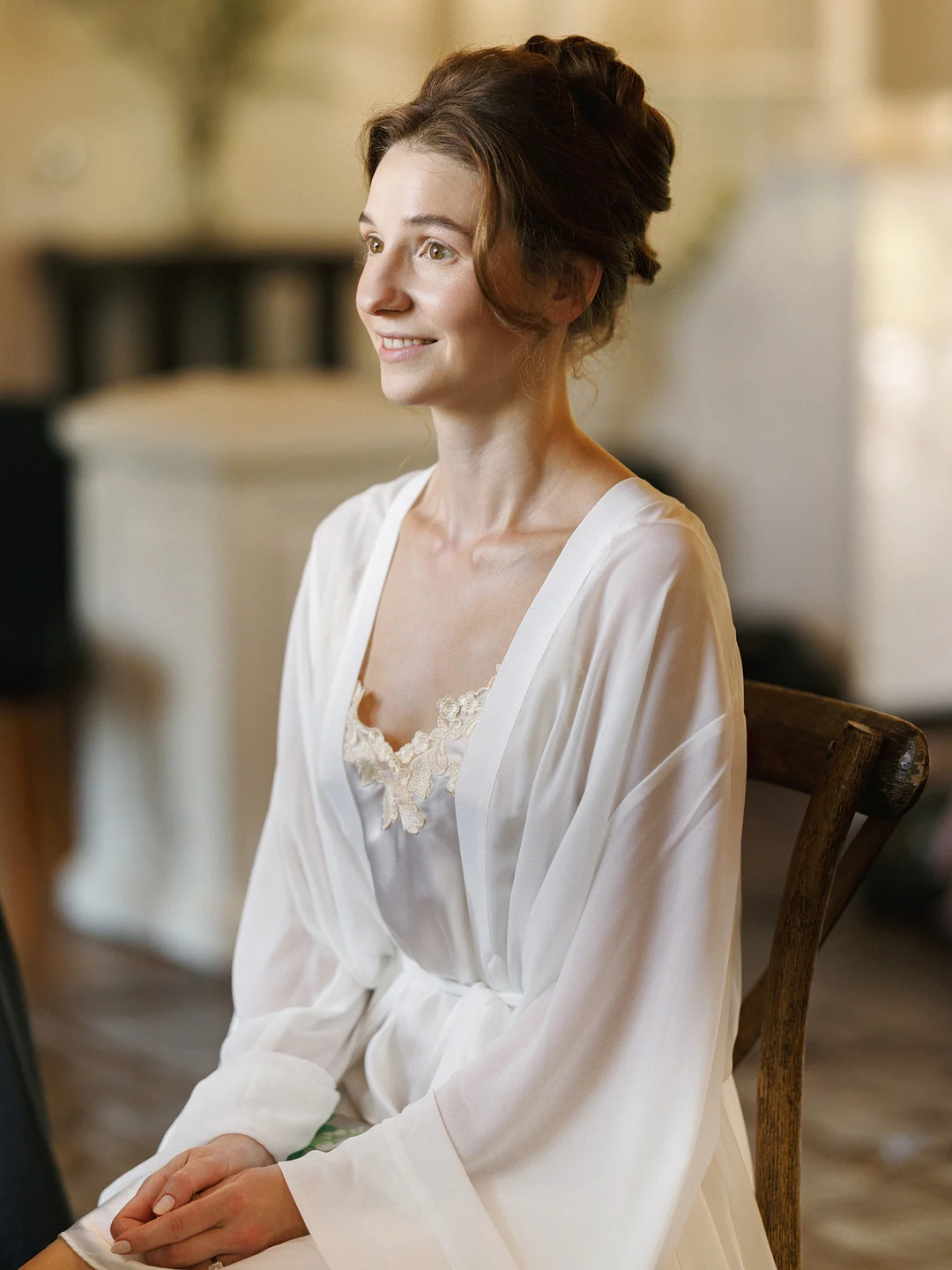 Baylee dans une robe blanche près de la fenêtre tout en se préparant à La Venta Inn