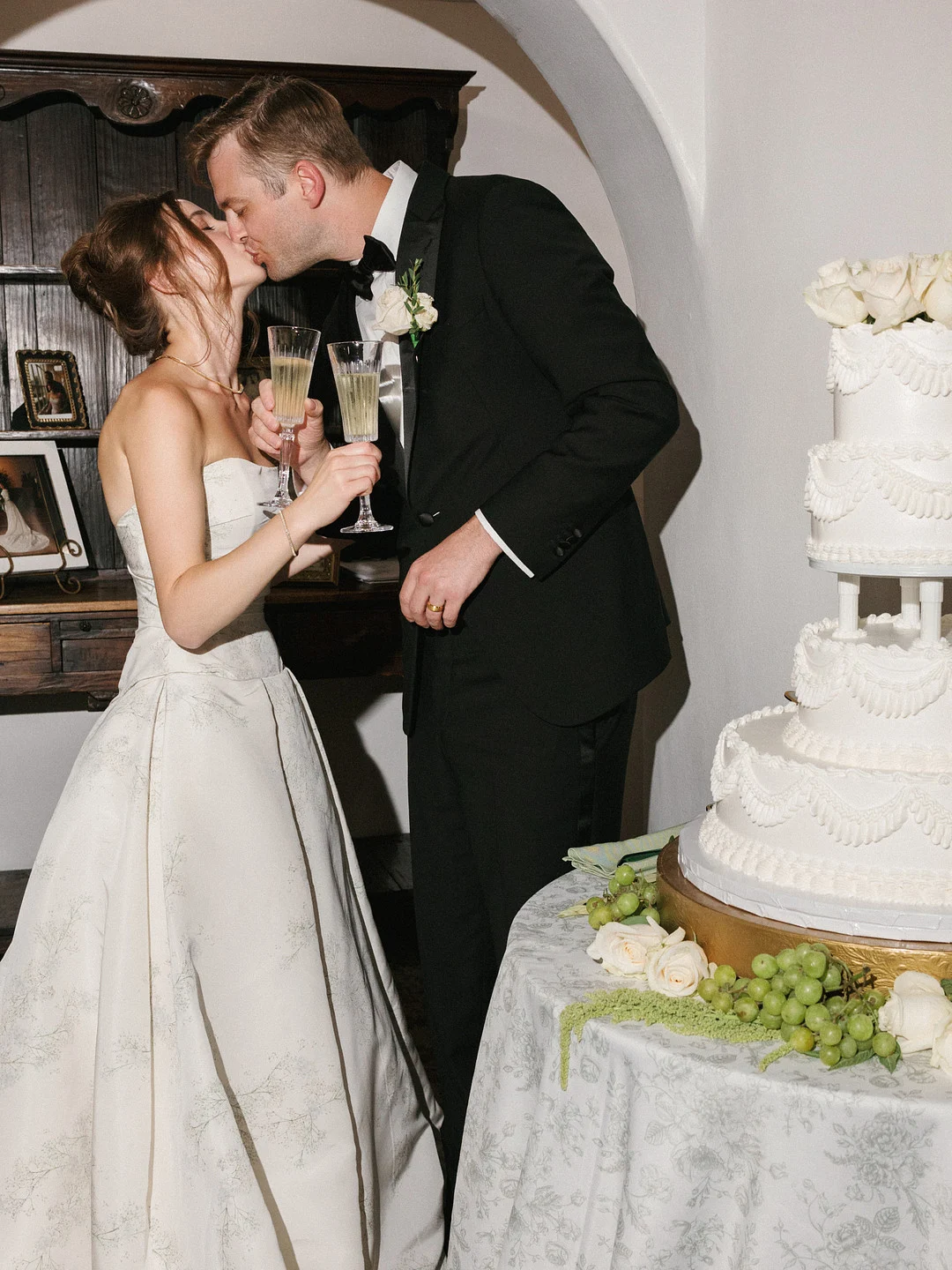 Baylee et Avery s'embrassent avec du champagne à la main après avoir coupé leur gâteau de mariage