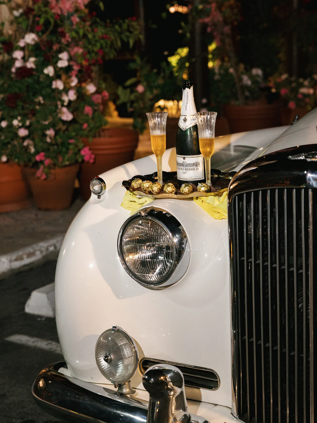 Champagne et verres sur le capot de la voiture d'escapade Bentley vintage du couple