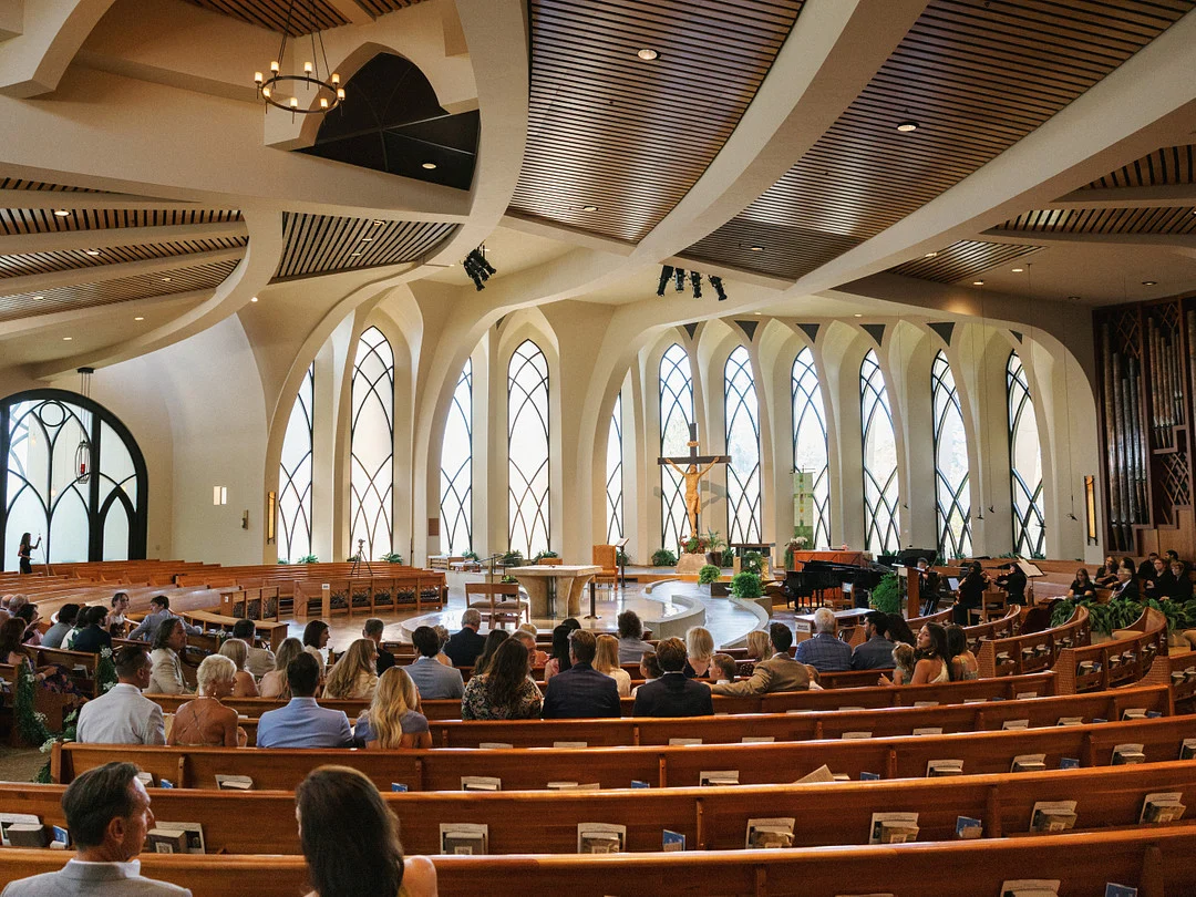Invités remplissant les bancs de l'église catholique St. John Fisher avant la cérémonie