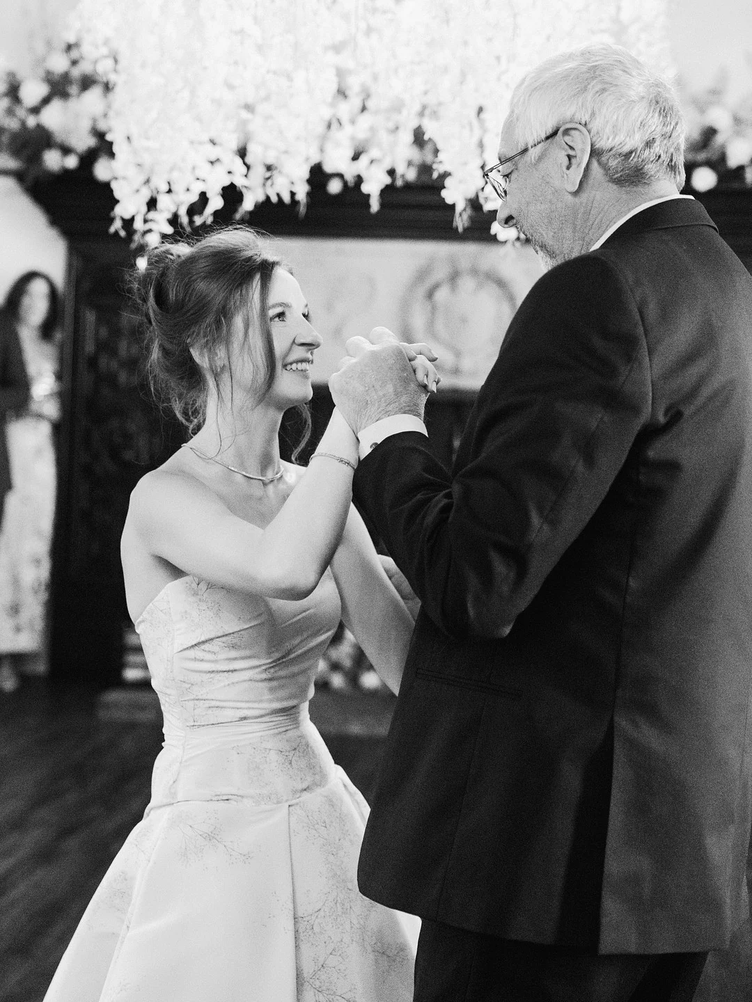 Photo en noir et blanc de Baylee dansant avec son père à la réception