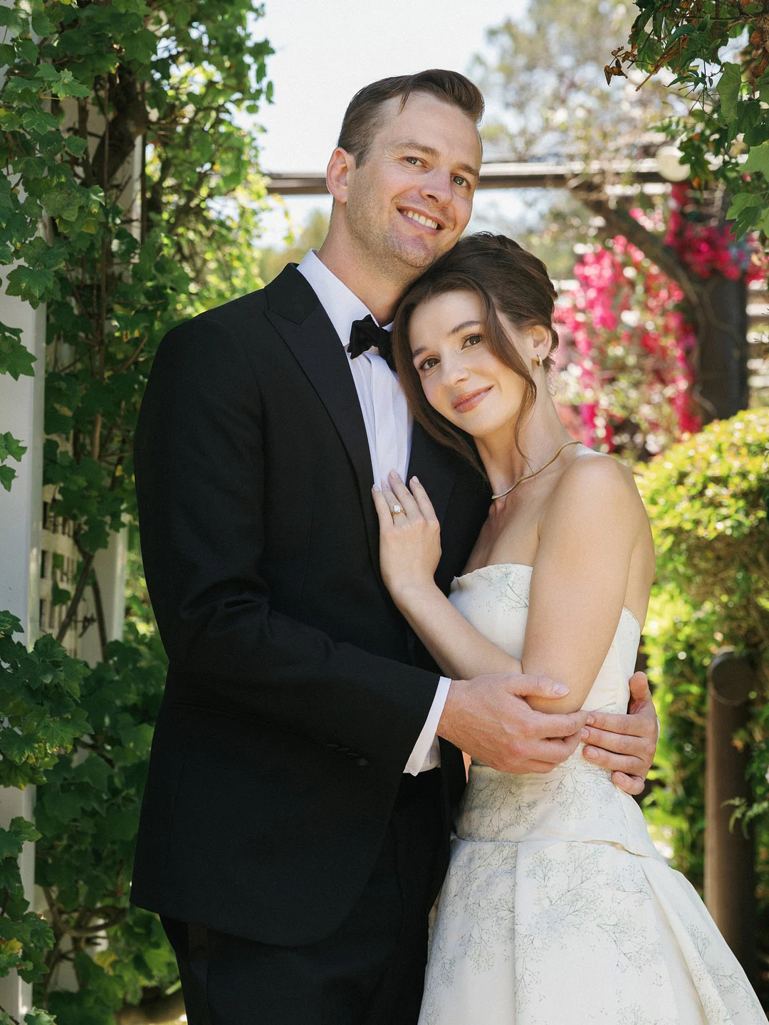 Baylee et Avery s'embrassent dans les jardins de La Venta Inn après leur cérémonie de mariage à Palos Verdes