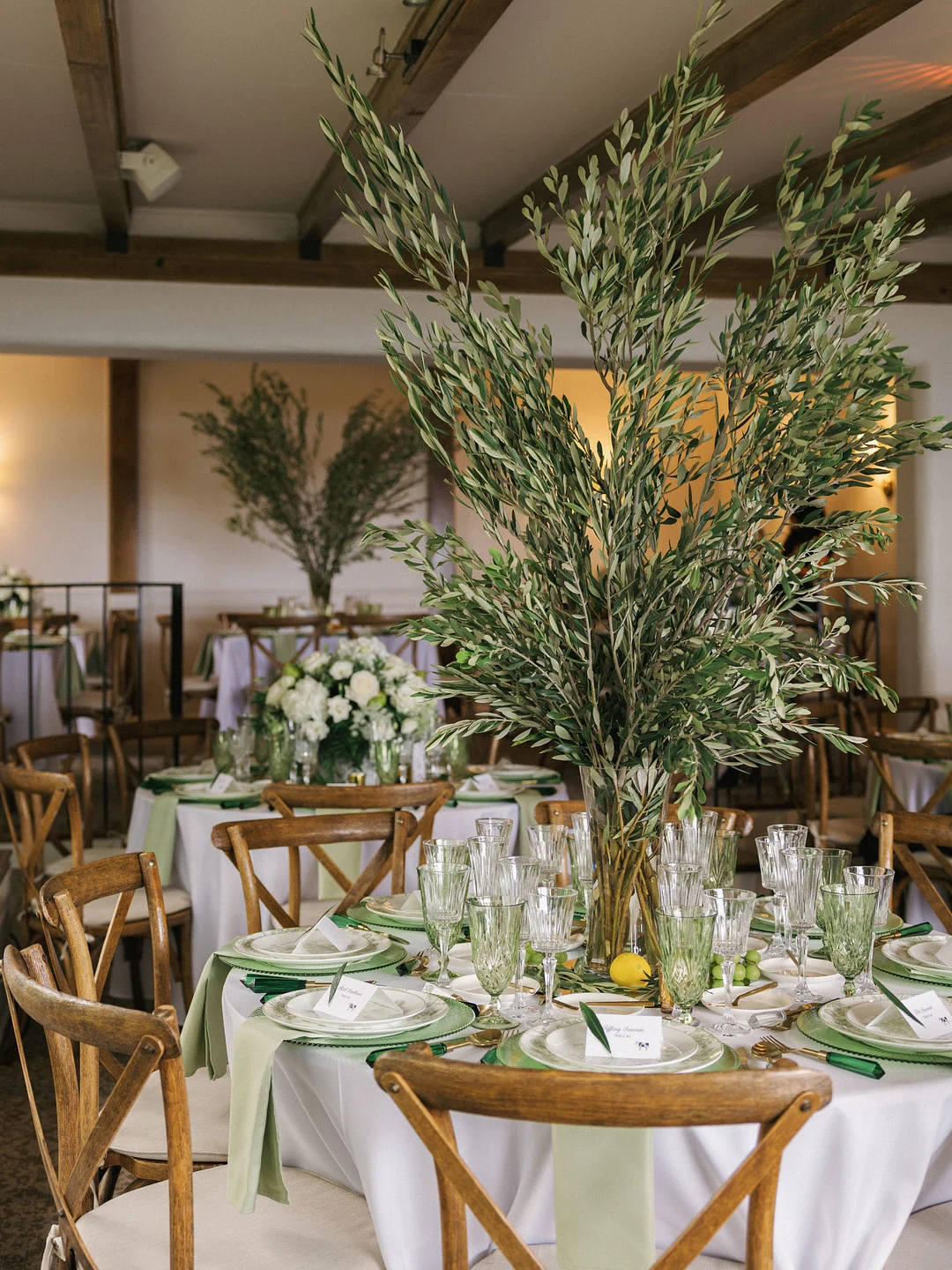 Tables de réception à La Venta Inn avec de grands centres de table en branche d'olivier et des accents verts