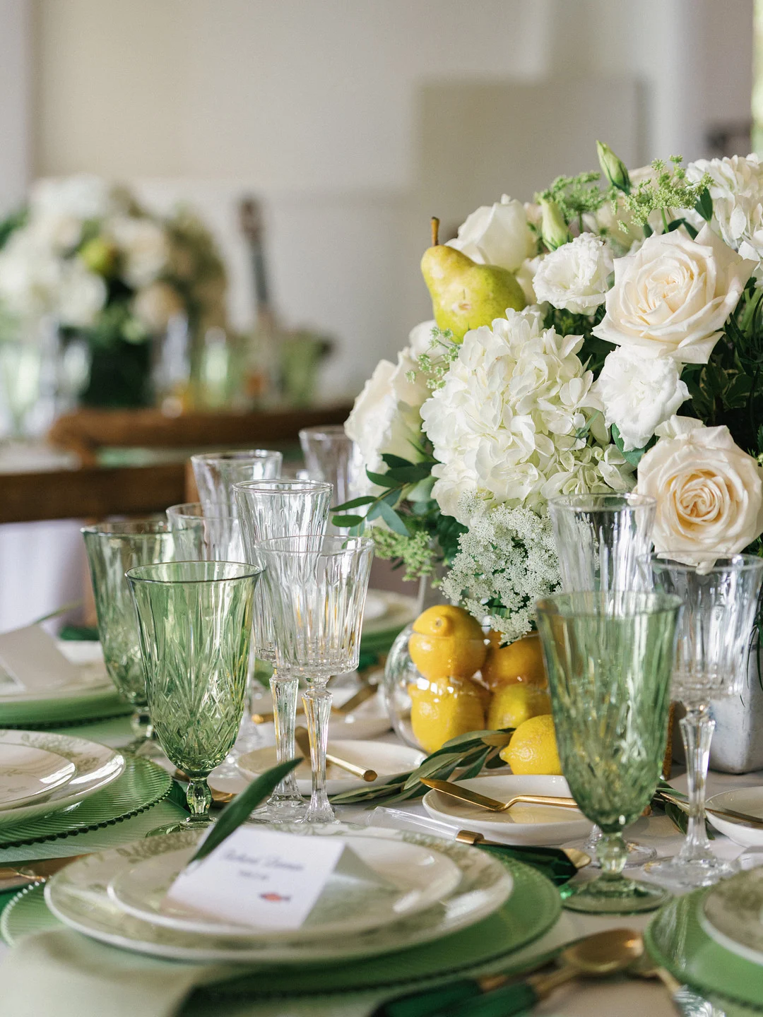 Tablescape avec des gobelets verts, des hortensias blancs, des roses et des citrons frais